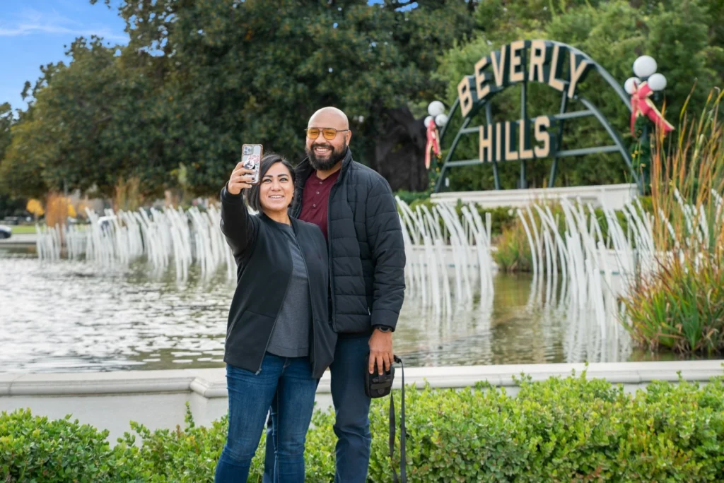couple taking selfie in front of Beverly Hills sign landmark