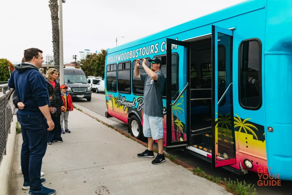 Hollywood Bus Tours vehicle parked while guide photographs guests