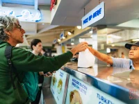 visitor receiving food order at Original Farmers Market Los Angeles