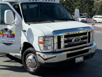 Hollywood Bus Tours van parked with scenic mountain background