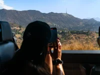tourist photographing Hollywood Sign from Hollywood Hills viewpoint