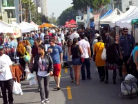 crowded Los Angeles street market with food vendors and shoppers