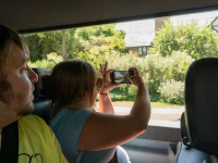 tourist taking photos of celebrity homes during Hollywood bus tour