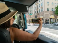 tourist taking photo of Rodeo Drive from tour vehicle