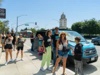 tourists standing beside Hollywood bus tour van in Beverly Hills
