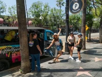 tourists standing on Hollywood Walk of Fame beside tour bus