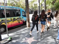 tourists walking past Hollywood Bus Tours van on Hollywood Walk of Fame