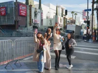 Group of friends taking selfies during a Hollywood Bus Tours experience on Hollywood Boulevard.