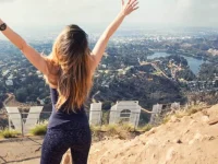 woman standing near Hollywood sign viewpoint in Los Angeles hills