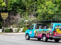 Hollywood Bus Tours vehicle parked near Beverly Hills city sign
