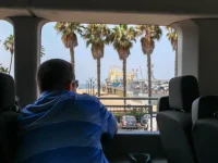 Hollywood Bus Tours vehicle near Santa Monica Pier entrance sign