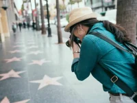 tourist photographing Hollywood Walk of Fame stars